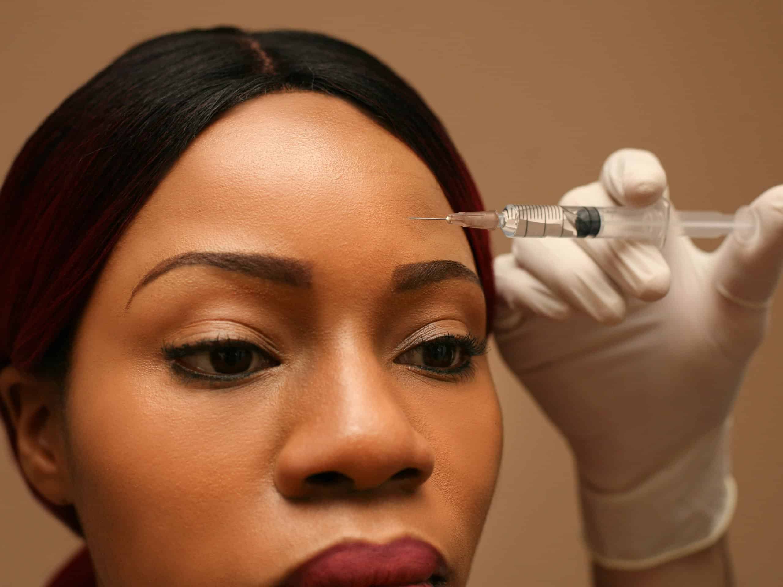 Person receiving a cosmetic forehead injection.