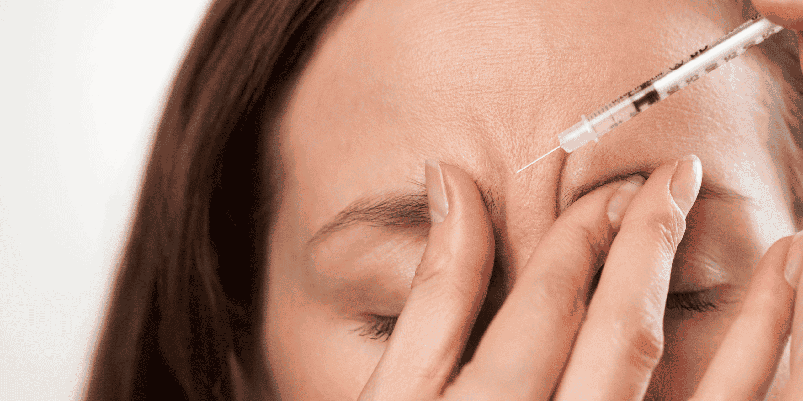 Person receiving forehead injection with syringe.