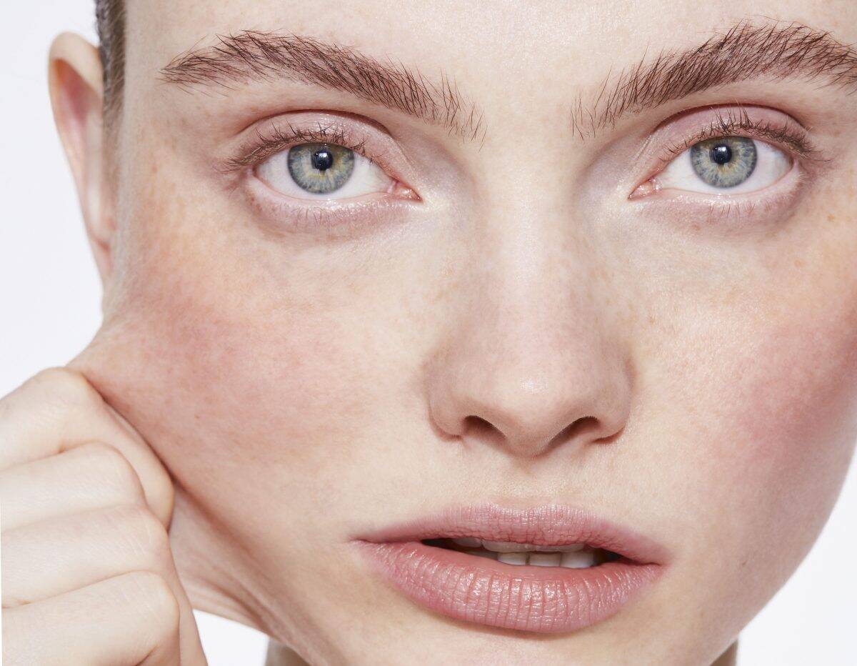 Close-up of a person pulling facial skin.