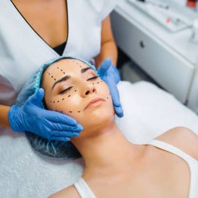 Cosmetician makes botox injection in dotted lines cosmetician makes botox preperation lines on woman's face