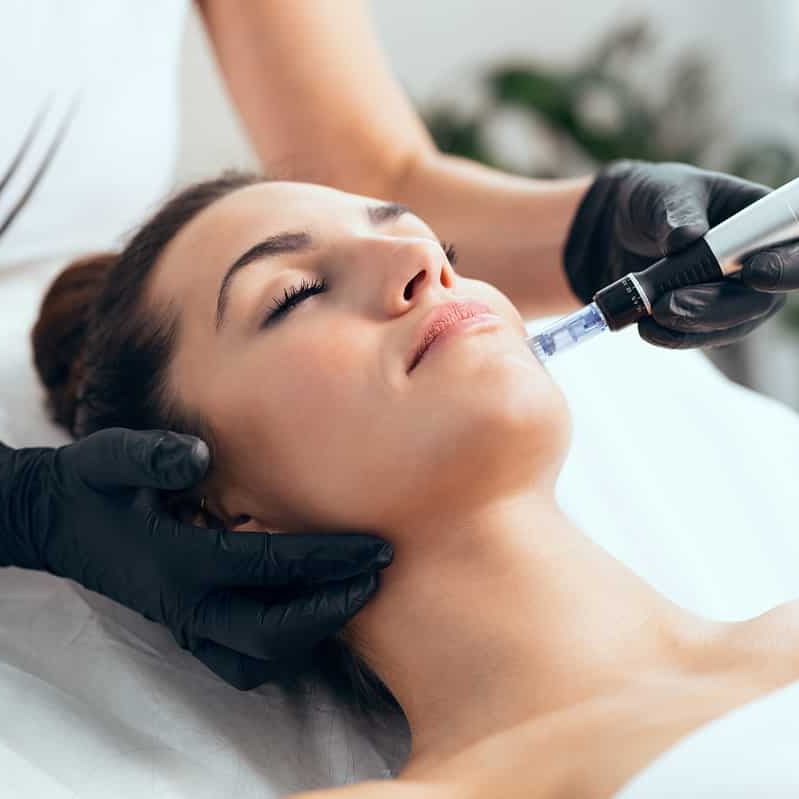 cosmetologist making mesotherapy injection with dermapen on face