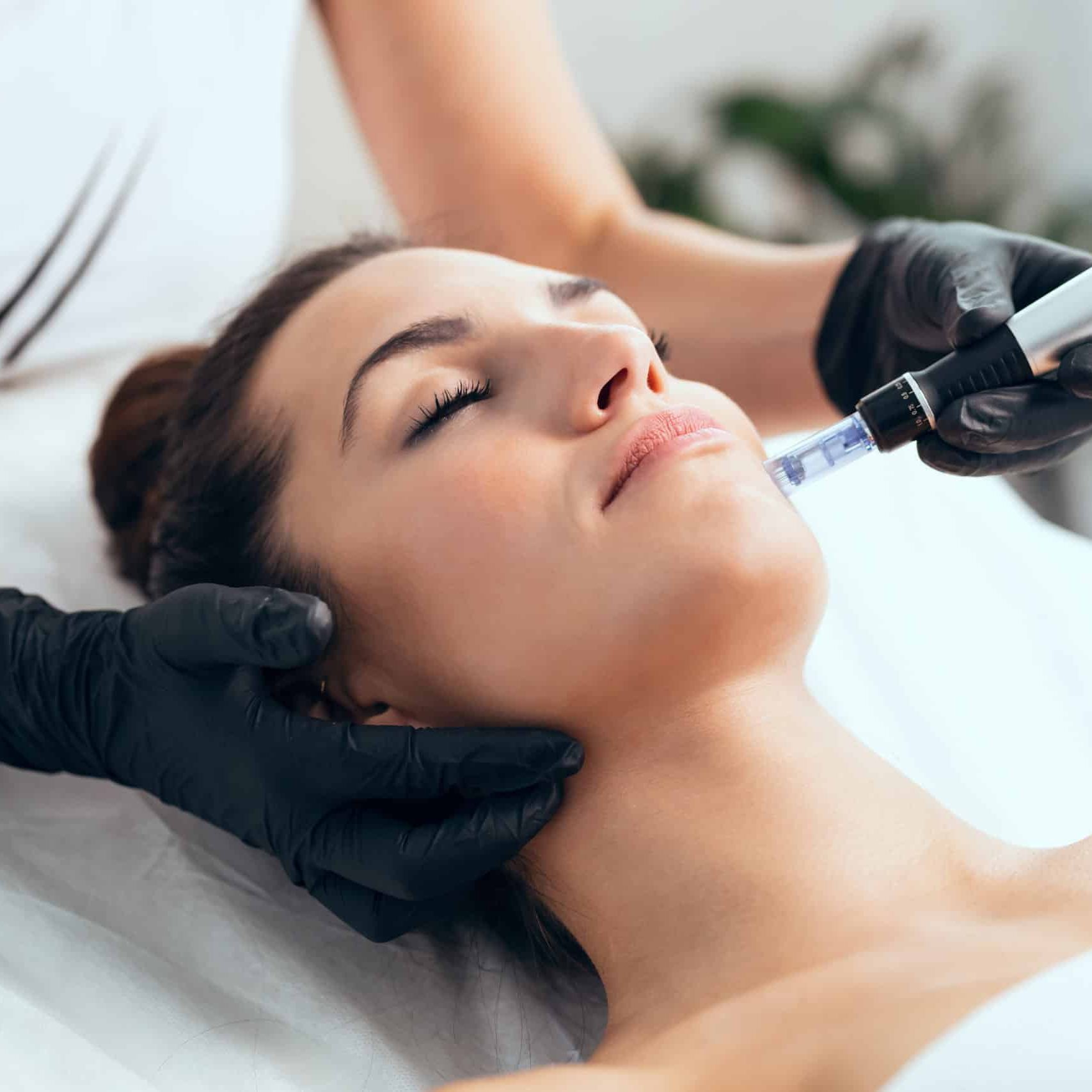 cosmetologist making mesotherapy injection with dermapen on face