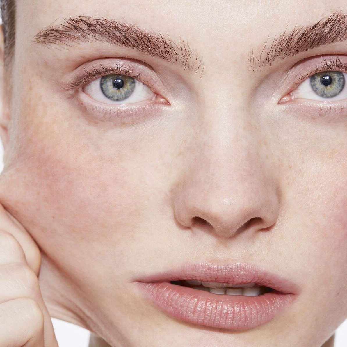 Close-up of a person pulling facial skin.